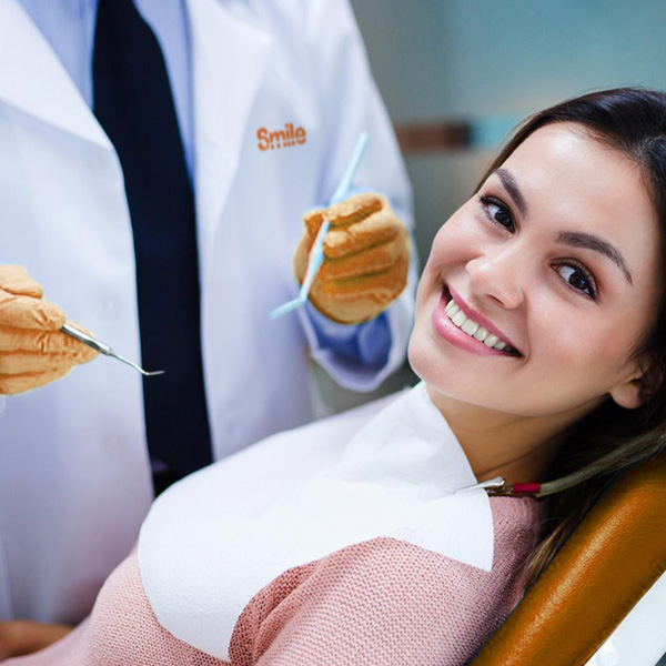 Fotografi di un dentista dei centri Smile durante la visita di una giovane paziente